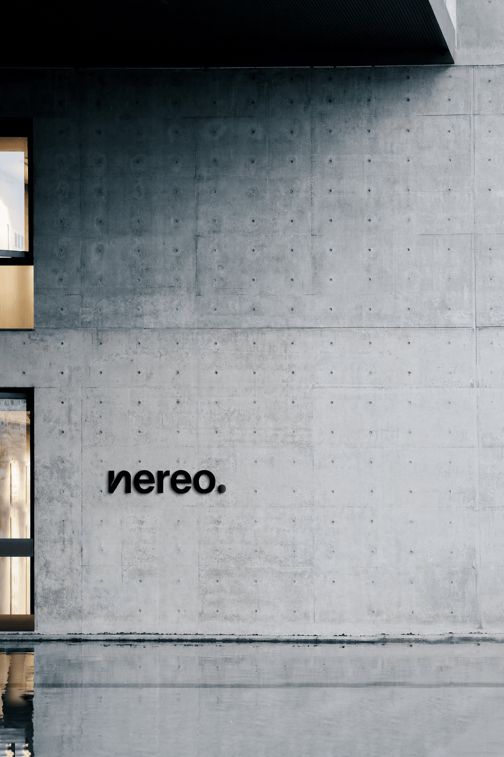nereo signage on a concrete facade above a reflecting pool